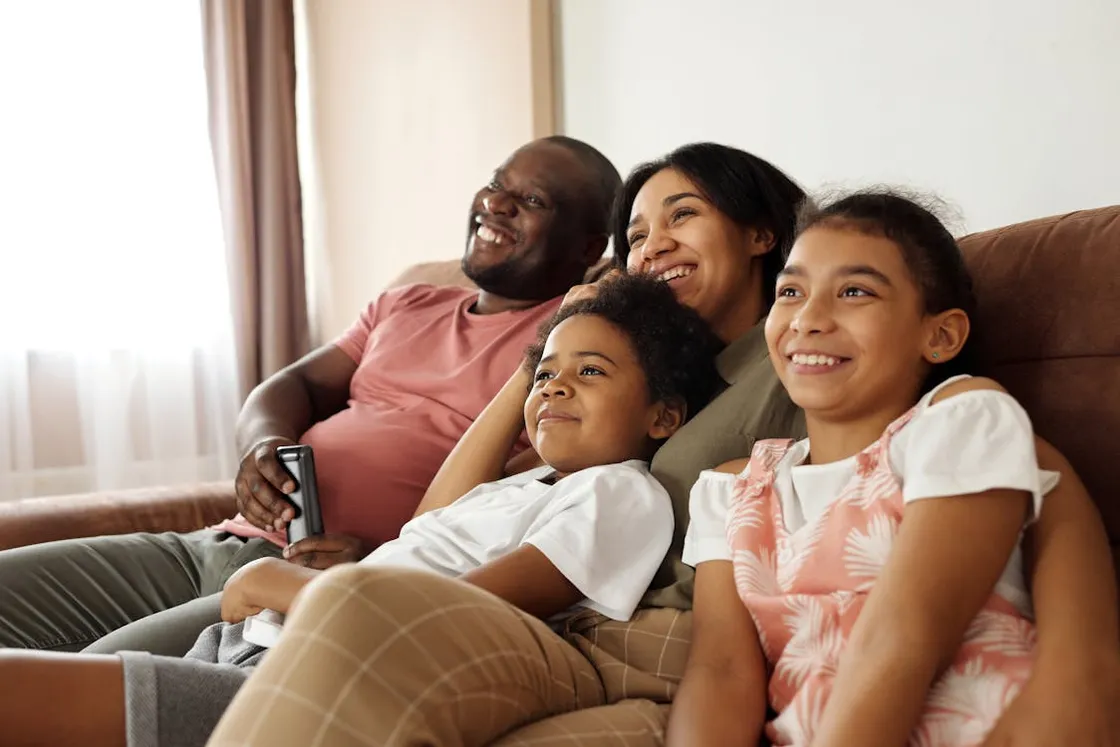 Multicultural family enjoying time together on a couch, illustrating the kind of diverse Florida households that benefit from beneficiary structures and burial provisions tailored to multiple traditions