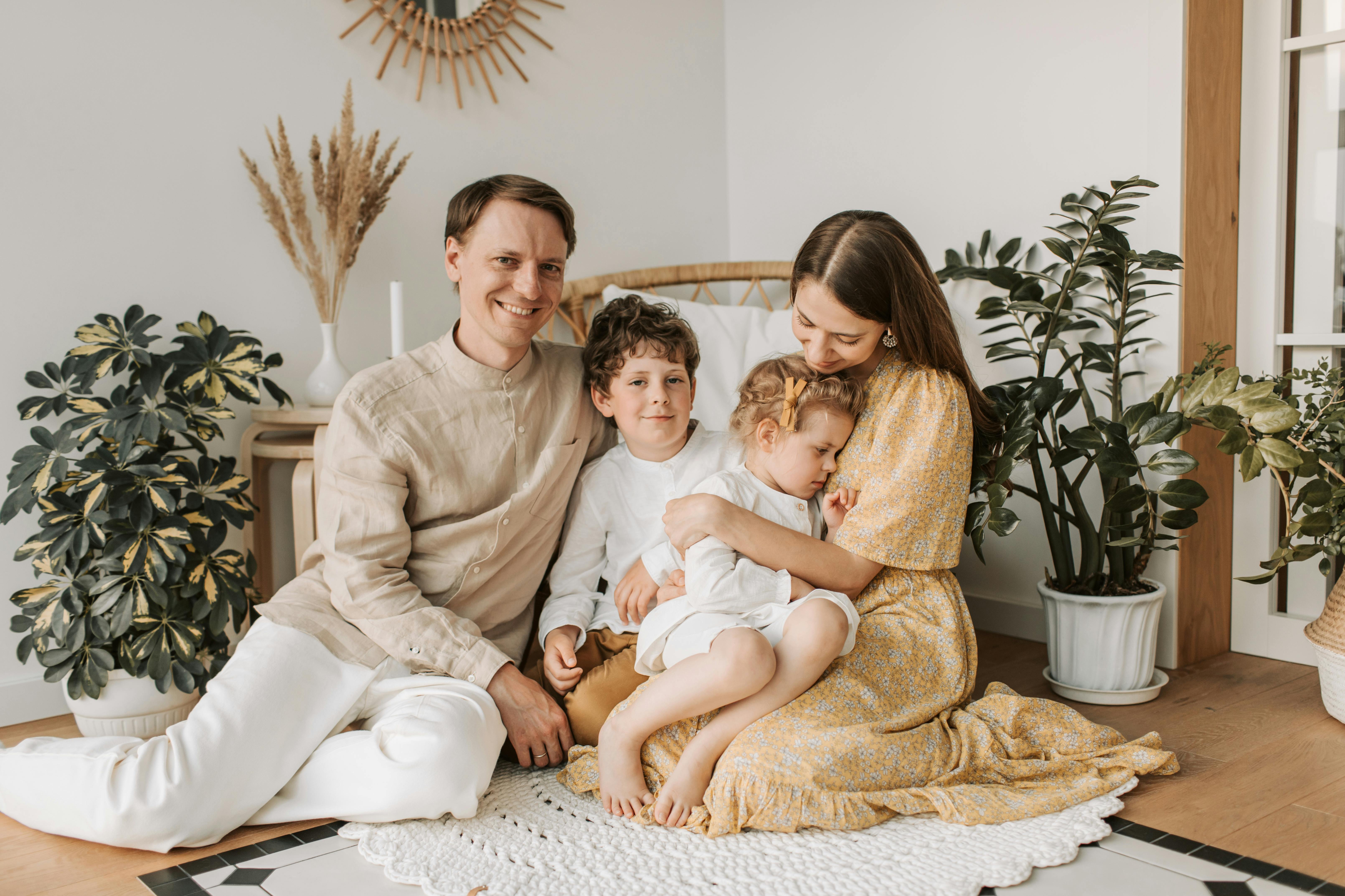 Parents enjoying quality time with toddlers at home, illustrating the shared family responsibilities that require coordinated life insurance coverage